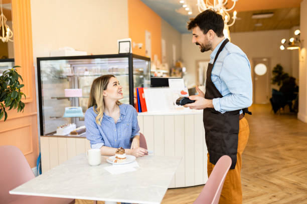 istock Shot of a young woman making a card payment using a nfc machine 2188525969