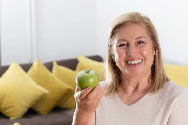 istock Smiling Woman Holding a Green Apple 2188527220