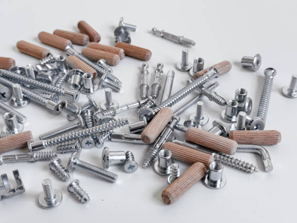 istock Assorted metal screws and wooden dowels on white surface 2188531199