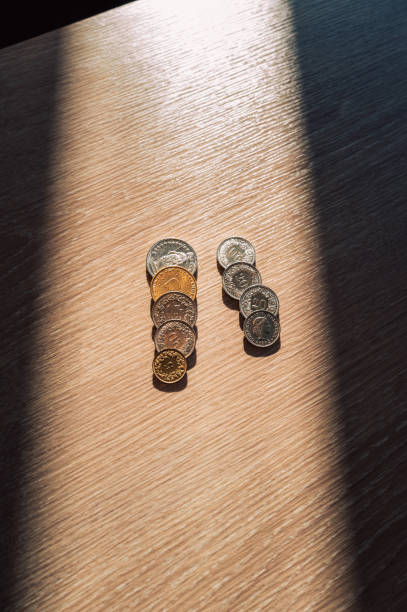 French franc coins forming the number eleven on a wooden table under dramatic lighting