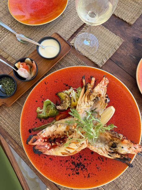 istock Table setting for beach bbq with seafood plates serving lobster and prawns in sunny Maldives beach restaurant 2188535991