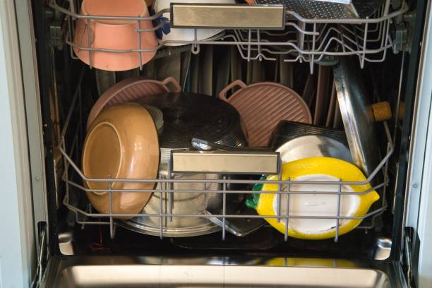 istock Dishes piled chaotically in dishwasher during dishwashing cycle 2188537891