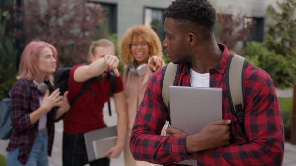 Sad upset offended victim boy student guy African American suffering man bullied of group multiracial students teens classmates thumb down mocking bully abused bullying university college aggression Sad upset offended victim boy student guy African American suffering man bullied of group multiracial students teens classmates thumb down mocking bully abused bullying university college aggression. High quality 4k footage pain points stock pictures, royalty-free photos & images