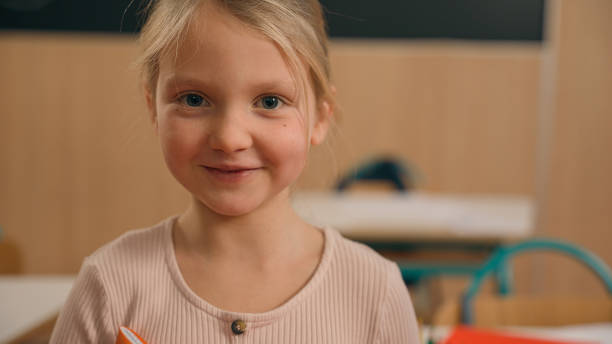istock Caucasian clever happy little girl school test study task exam writing notes class lesson learn write copybook kid schoolgirl child pupil studying learning primary education smiling at camera at desk 2188538829
