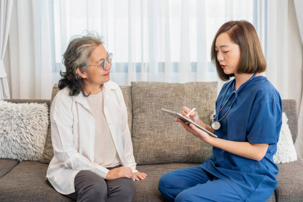 istock asian female nurse in uniform visiting a senior patient at home using tablet computer evaluate,collect data and giving advice,elderly health care,home care 2188539606