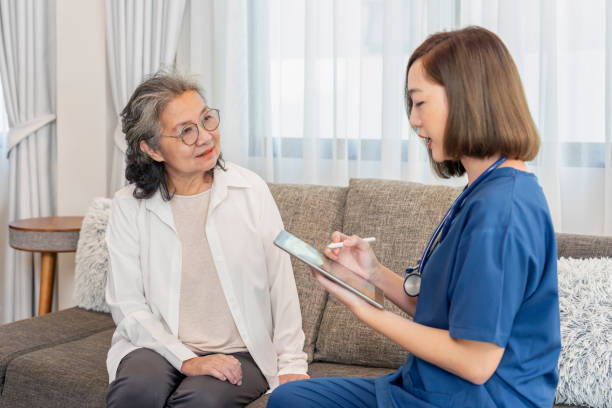 istock asian female nurse in uniform visiting a senior patient at home using tablet computer evaluate,collect data and giving advice,elderly health care,home care 2188539611