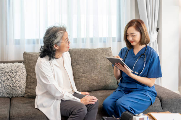 istock asian female nurse in uniform visiting a senior patient at home using tablet computer evaluate,collect data and giving advice,elderly health care,home care 2188540125