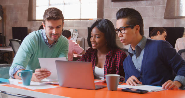 istock Three Designers In Creative Business Using Laptop Meeting In Modern Multi-Cultural Office 2188540204