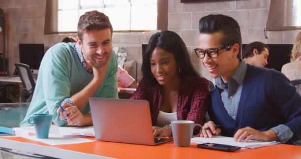 istock Three Designers In Creative Business Using Laptop Meeting In Modern Multi-Cultural Office 2188540213