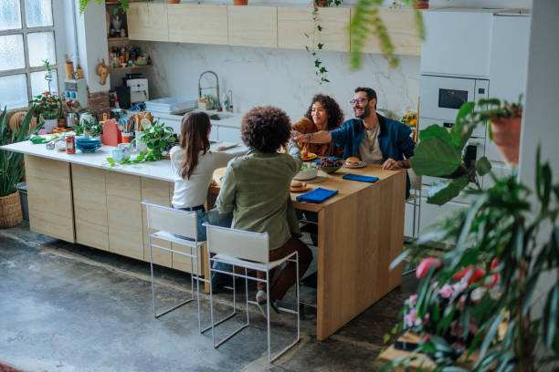 istock Friends enjoying a meal together in modern kitchen 2188540258