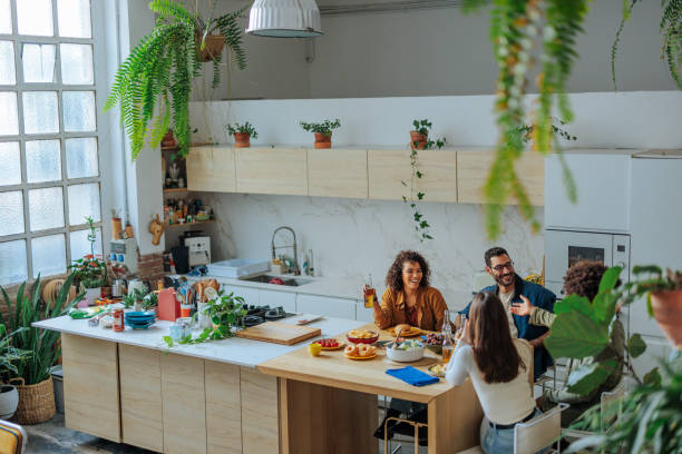 istock Cheerful friends enjoying a meal together in a modern kitchen 2188540261