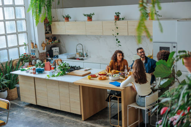 istock Cheerful friends enjoying a meal together in a modern kitchen 2188540268