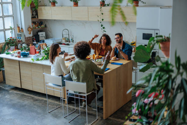 istock Cheerful friends enjoying a meal together in a modern kitchen 2188540270