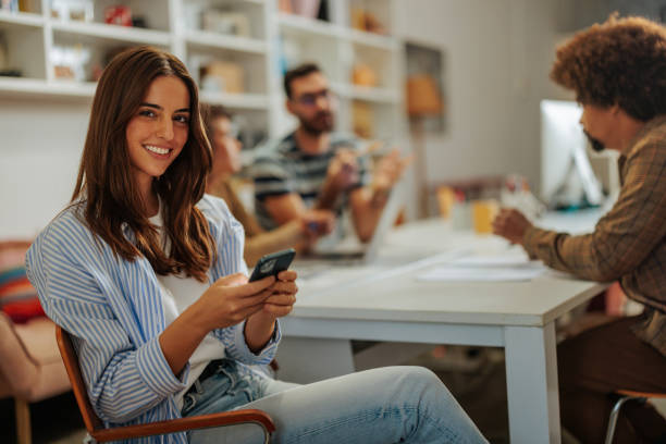 istock Young businesswoman using smartphone during a meeting with colleagues 2188540334