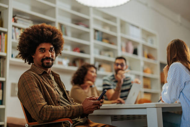 istock Young businessman using phone during a meeting with colleagues in the office 2188540357