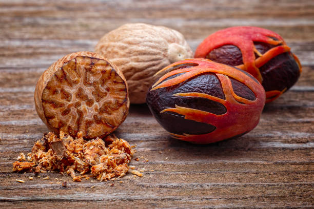 Nutmeg (Myristica fragrans), Myristicaceae. Spice, fresh nut with mace. On wooden table.