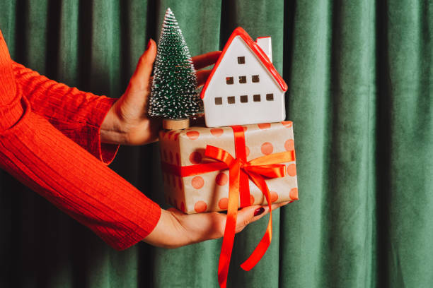 istock Female hand hold gift box and Christmas decorations on green curtains background 2188543778
