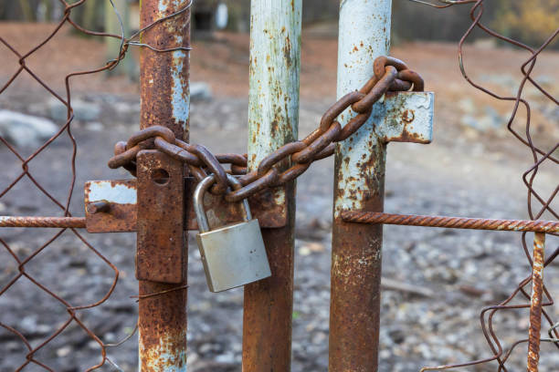 istock The metal gate is locked with a chain and has a padlock. 2188546456