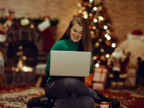 istock Woman using laptop computer on Christmas Eve at home 2188546543