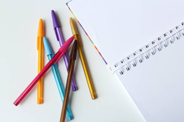 istock Bunch of colorful ballpens beside a spiral blank page notebook. 2188547508