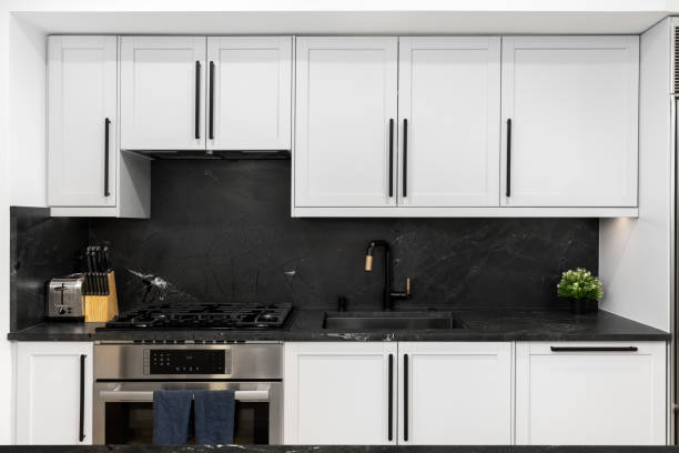 istock A white kitchen with a black stone countertop and backsplash. 2188547525