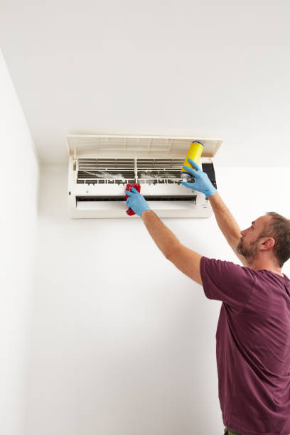 istock Man cleaning and maintaining air condition unit at home. 2188548415