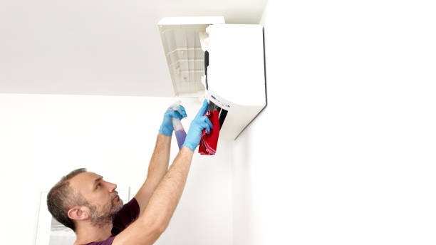istock Man cleaning and maintaining air condition unit at home. 2188548433