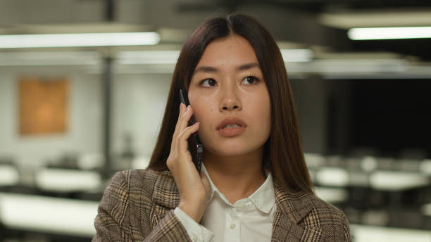 istock A woman is speaking on a cell phone while at her office work desk 2188548912