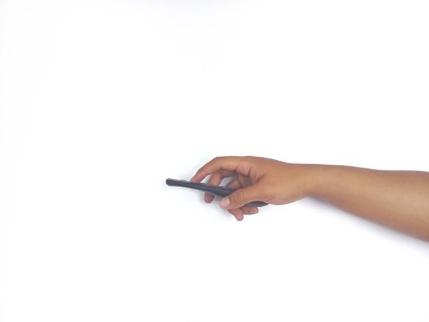 istock a hand holding a black remote control against a plain white background. The focus is on the remote, highlighting its buttons and ergonomic design. 2188549389