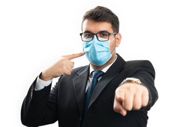 istock Male entrepreneur presenting medical mask pointing at camera 2188549481