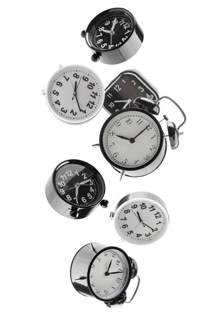 Beautifully retouched different alarm clocks falling in space. Isolated on white