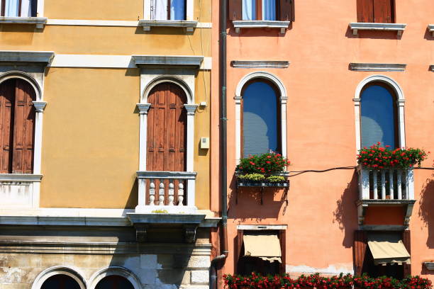 A closeup view of Venetian buildings showcasing vibrant colors and beautiful flowerfilled balconies