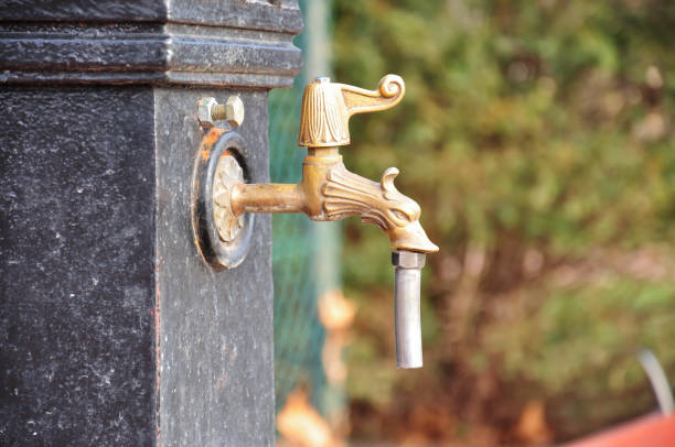 Antique Brass Fountain Tap with Ornate Design Outdoors.