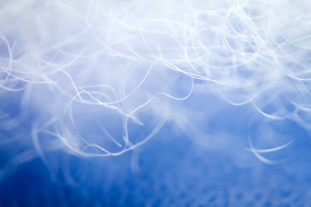Extreme macro of polyester stable fiber on blue background. Selective focus, shallow depth of field. Abstract dreamy background