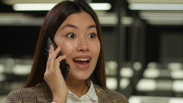 istock A woman is surprised while talking on her cell phone 2188563701