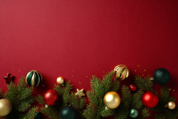Christmas tree branches with baubles and stars on red background. New nostalgia style. Ideal for seasonal greetings, holiday marketing, and winter celebration themes
