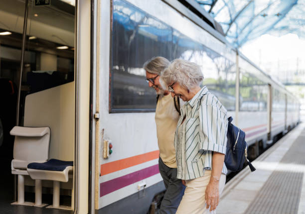 istock Happy senior couple boarding train at railway station 2188571416