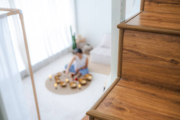 Portrait of beautiful Asian woman playing Tibetan singing bowls for meditation at living room. Tibetan singing bowls can be powerful tools for deepening your meditation practice and cultivating inner peace.