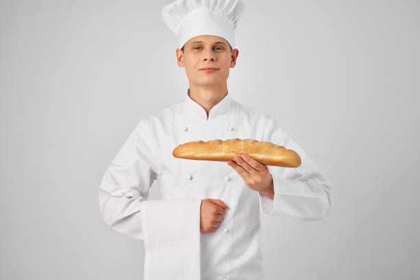 istock a man in a chef's uniform holding a loaf baker preparing food 2188576131