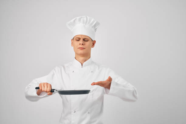 chef with a frying pan in hand kitchen service staff. High quality photo