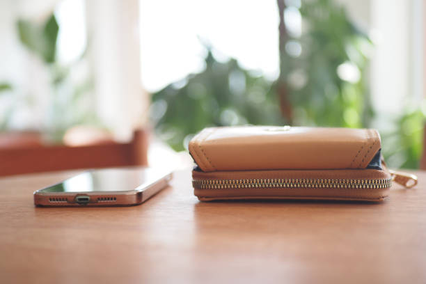 istock A Stylish Wallet and a Smartphone beautifully displayed on a Wooden Table surface 2188576673