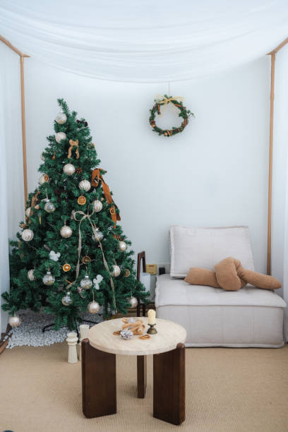 istock Eco-style Christmas interior with a large green Christmas tree against a white wall background in the living room. 2188578096