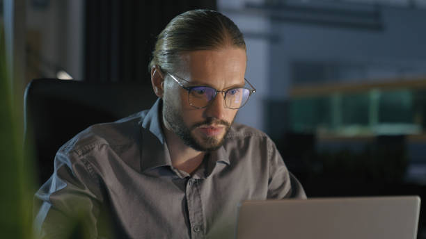 istock Overtime working businessman manager man at night evening dark office work with laptop serious concentrated business man worker company leader employer with computer job at table workplace late time 2188580190