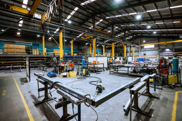 istock Large industrial warehouse with machinery and yellow support structures under bright overhead lighting 2188581204
