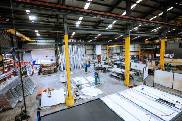 istock Large industrial warehouse with machinery and yellow support structures under bright overhead lighting 2188581230