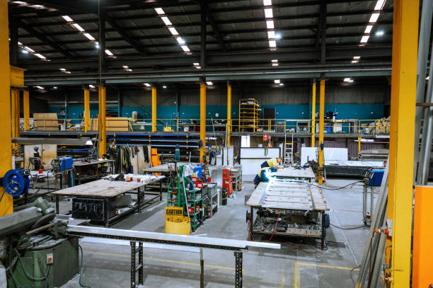 istock Large industrial warehouse with machinery and yellow support structures under bright overhead lighting 2188581232