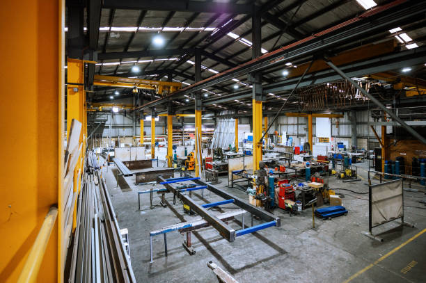 Large industrial warehouse with machinery and yellow support structures under bright overhead lighting