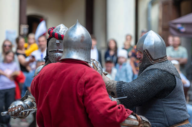 Jaunpils, Latvia - August 10, 2024: Knights clash with weapons in a thrilling historical reenactment event.