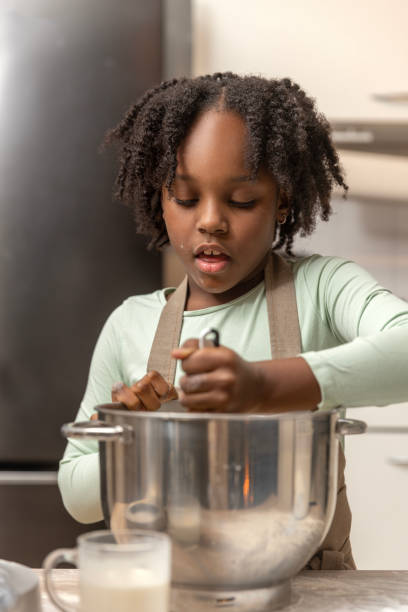 istock Beautiful young black girl preparing a xmas cake alone 2188584581