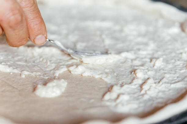 istock making pizza cooking at home spreading souse cream cheese on a dough 2188585467